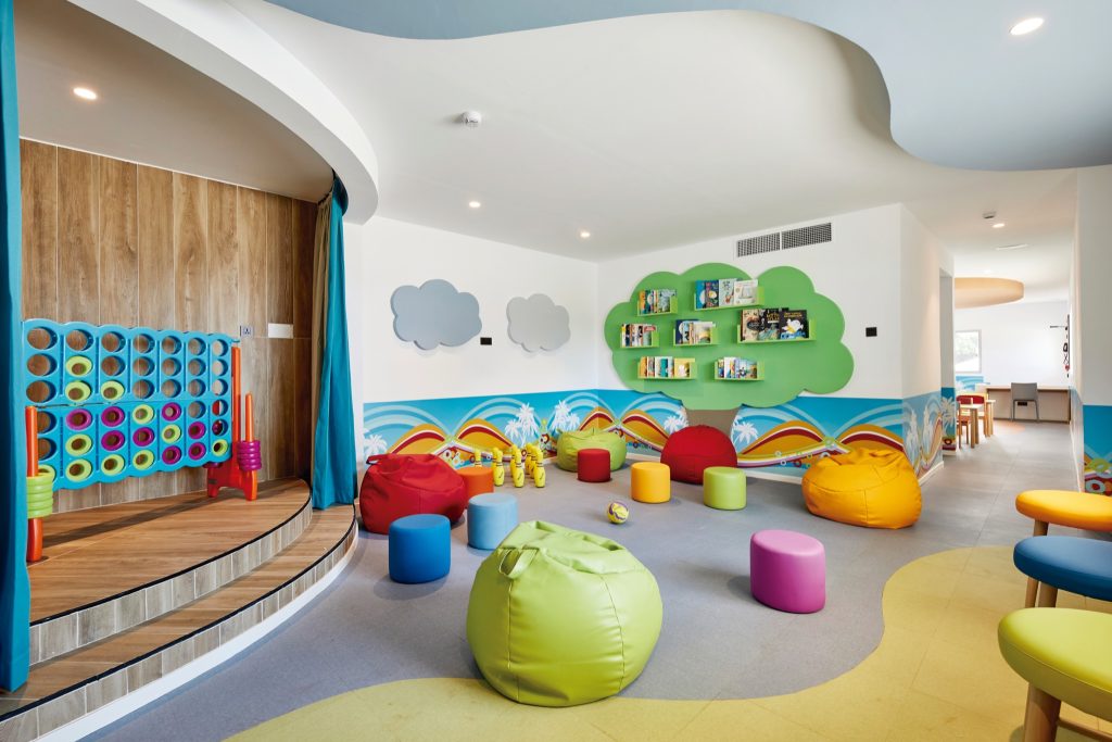 Bunter Spielraum im Hotel Riu Jambo mit Sitzkissen in Rot, Gelb, Lila und Grün sowie Wanddekorationen mit Wolken