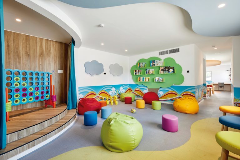 Bunter Spielraum im Hotel Riu Jambo mit Sitzkissen in Rot, Gelb, Lila und Grün sowie Wanddekorationen mit Wolken