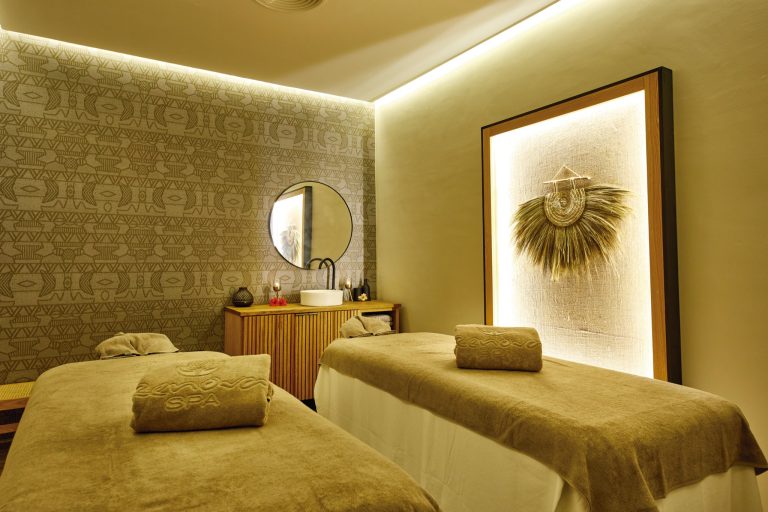 Spa-Raum im Hotel Riu Jambo mit zwei Massagebetten, filigranem Kunstwerk und geometrischen Wandmustern