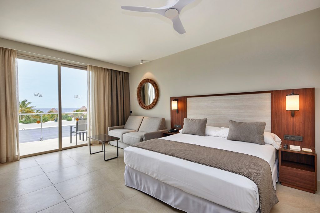 Hotel Riu Jambo Zimmer Superior Sea View mit großem Bett, Holz- und Stoffelementen, Terrasse, Pool und Palmen