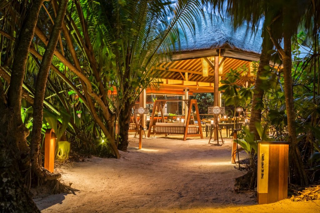 Offener Pavillon mit Strohdach und Holzbankmöbeln im Restaurant The Island Grill auf den
