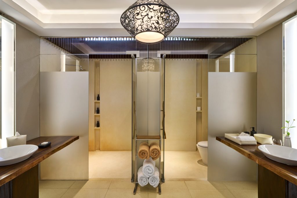 Badezimmer mit zwei dunklen Holzwaschtischen und weißen Waschbecken in der 2 Bedroom Beach Pool Villa