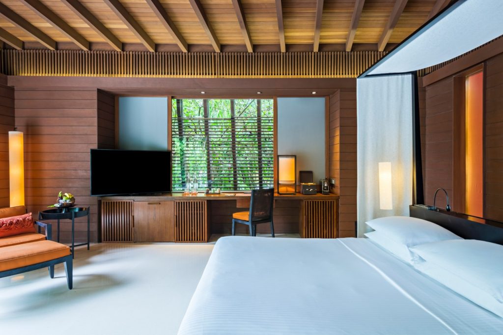 Zimmer der Beach Villa im Park Hyatt Maldives Hadahaa mit Holzwänden, weißer Bettwäsche und großem Fenster