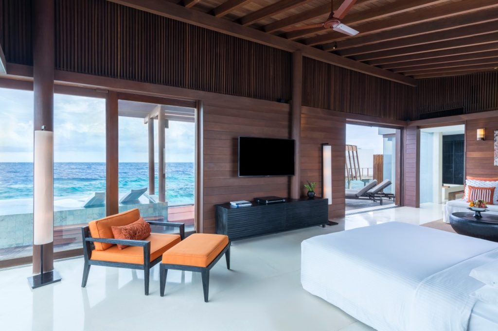 Modernes Zimmer mit Holzwänden, großer Glasfront und Blick auf das Meer auf den