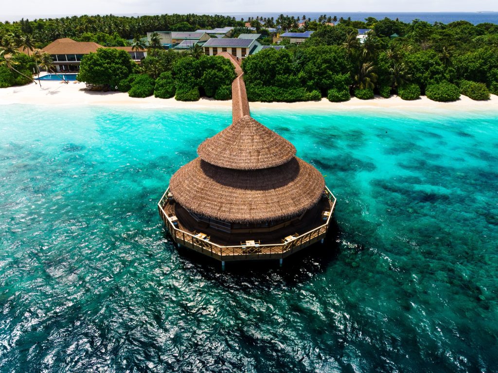 Rundes Restaurant Dhiyavaru mit strohgedecktem Dach über türkisblauem Meer auf den