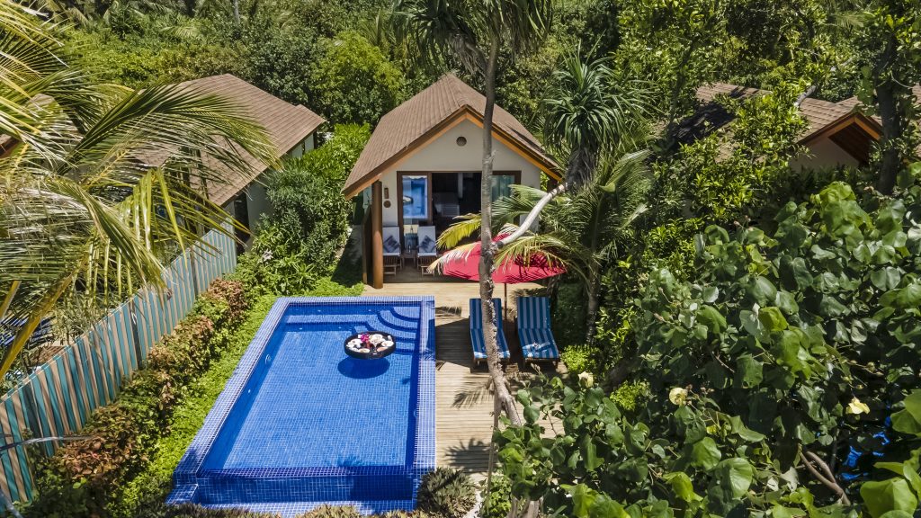 Deluxe Beach Pool Villa mit privatem Pool, blauen Liegestühlen und rotem Sonnenschirm auf Holzdeck