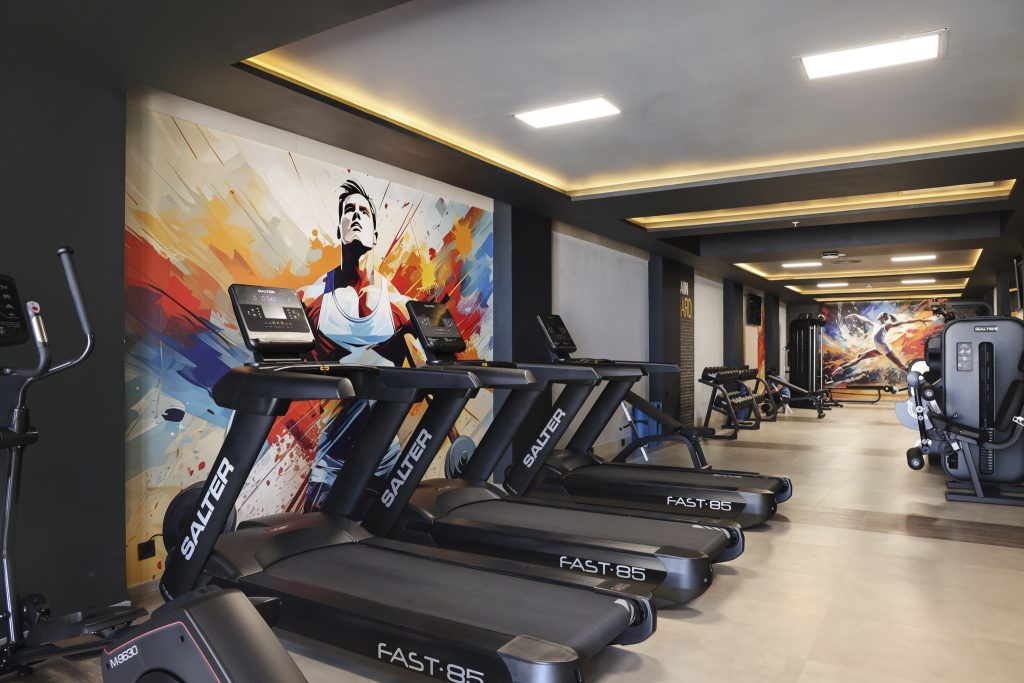 Moderner Fitnessraum im Hotel Riu Palace Swahili mit Laufbändern und farbiger Wandgestaltung in Sansibar