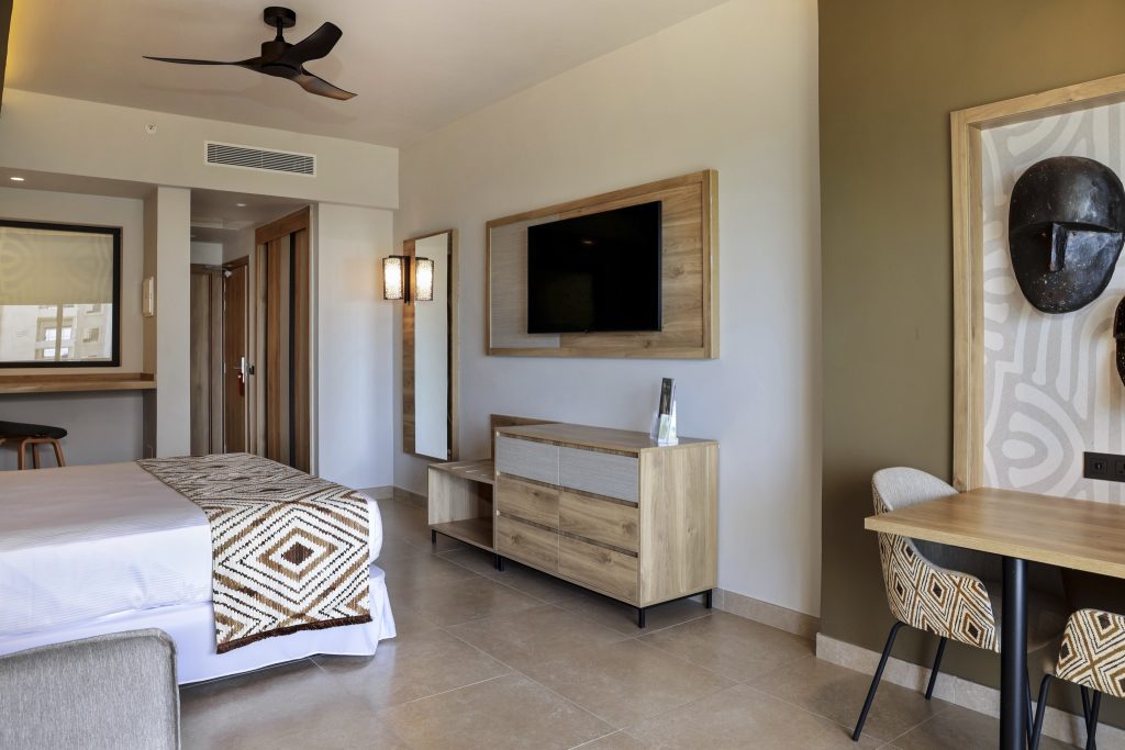 Modern eingerichtetes Hotelzimmer mit Doppelbett, Holzschreibtisch und Wandfernseher im Hotel Riu Palace Swahili