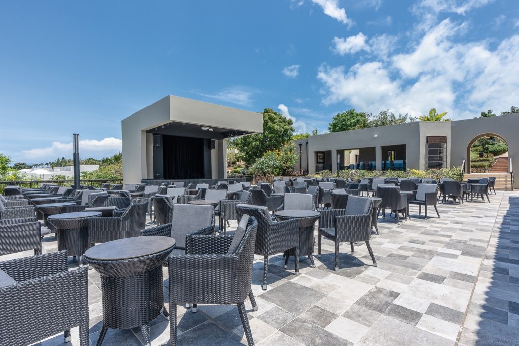 Terrasse der Bar Coffee Lounge im Riu Palace Zanzibar mit grauen Sitzgruppen und einer überdachten Bühne