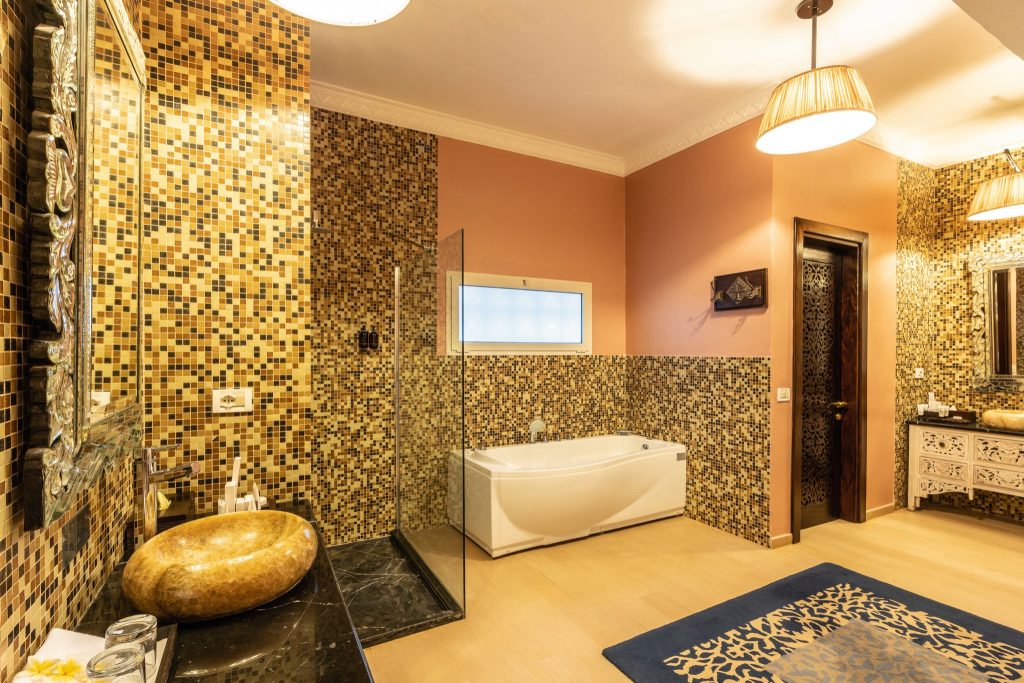 Badezimmer der Beach Villa im Riu Palace Zanzibar mit goldfarbenem Waschbecken, Mosaikfliesen