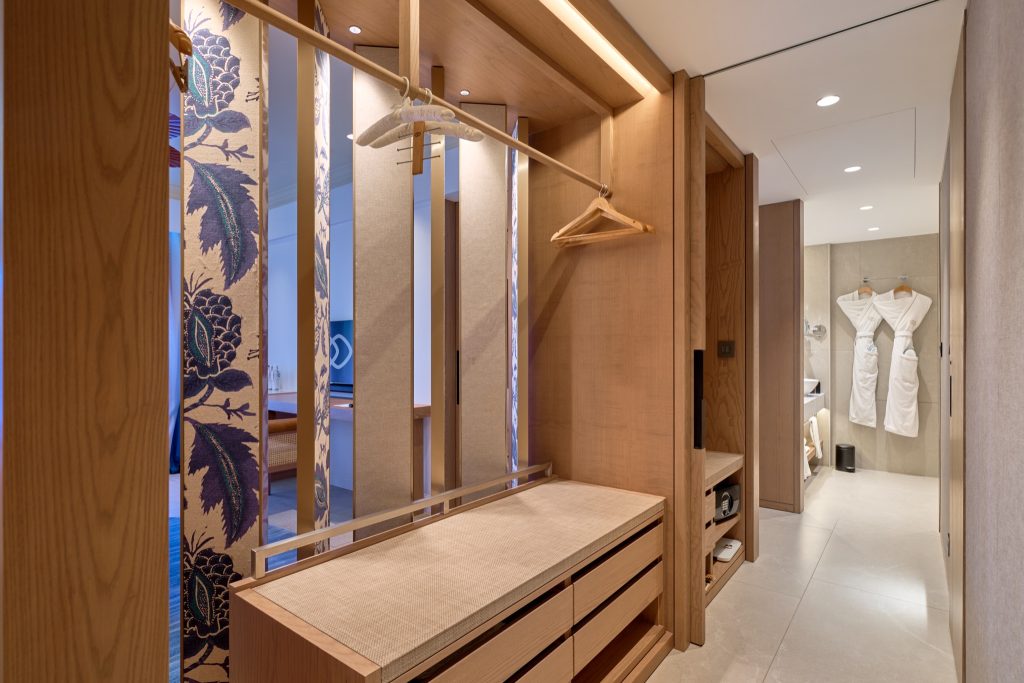 Blick in die Family Suite mit offenem Schrank aus hellem Holz und angrenzendem Badezimmer im Sofitel Mauritius