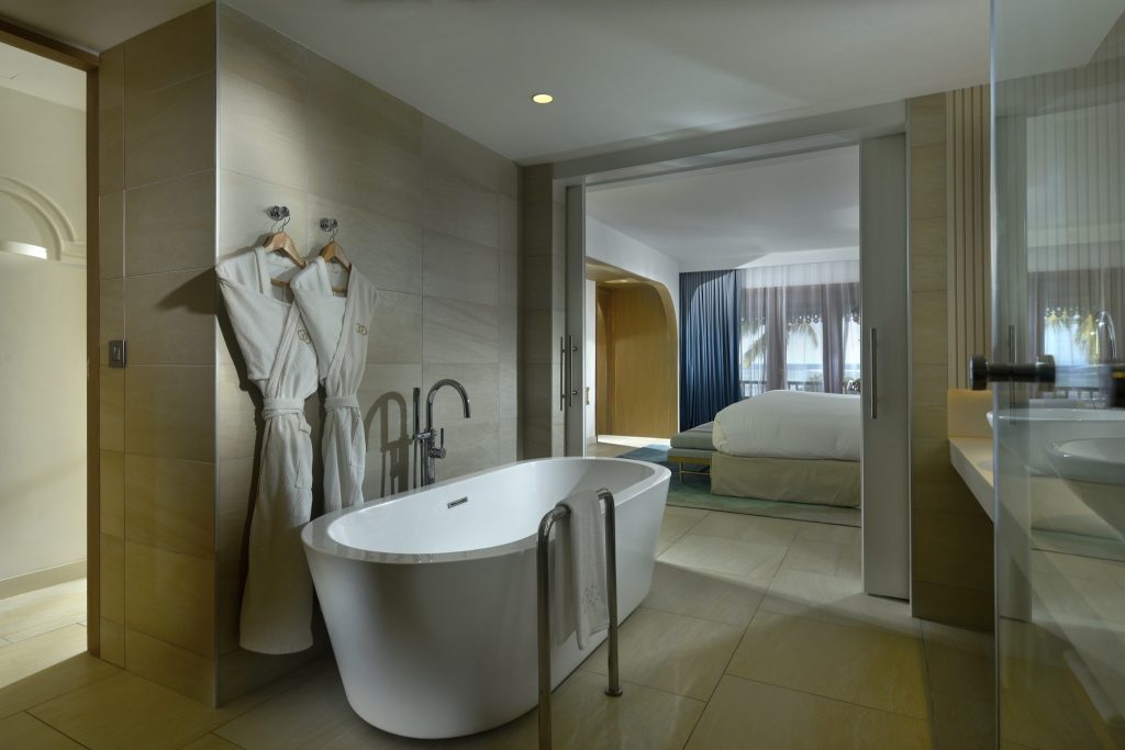 Modernes Zimmer der Opera Suite mit offenem Badezimmer, freistehender Badewanne und großem Fenster