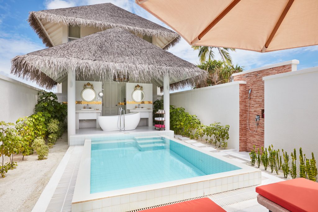 Beach Residence mit kleinem rechteckigen Pool, offenem Badezimmer mit freistehender Badewanne, Außendusche und weißen Wänden