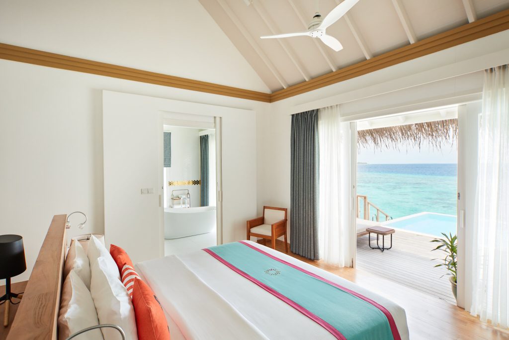 Ocean Residence Zimmer mit großem Bett, Holzterrasse, privatem Pool und offenem Meerblick bei Tageslicht