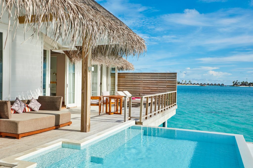 Terrasse der Two Bedroom Ocean Residence mit hellem Holz, Strohdach und Blick auf türkisblaues Meer bei Tageslicht