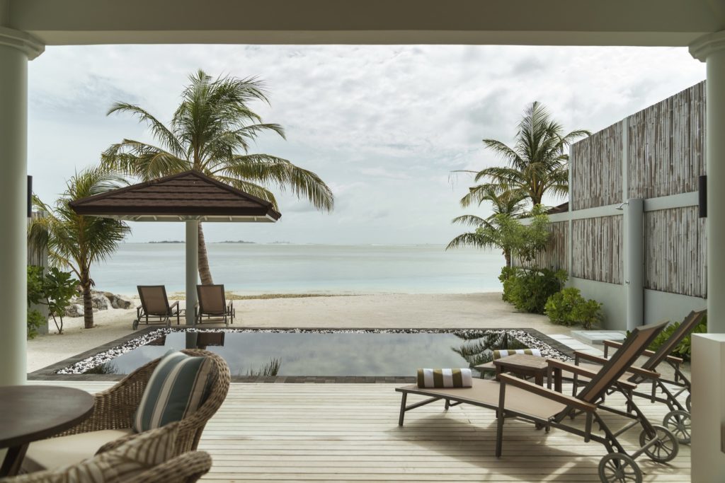 Außenbereich der 2 Bedroom Beach Residence mit Pool, Holzdeck, Liegestühlen und Blick auf Strand und Meer