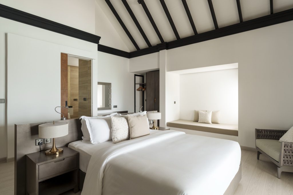 Zimmer der 2 Bedroom Beach Residence im Sun Siyam Olhuveli mit großem Bett, Nachttisch und hellem Holzboden