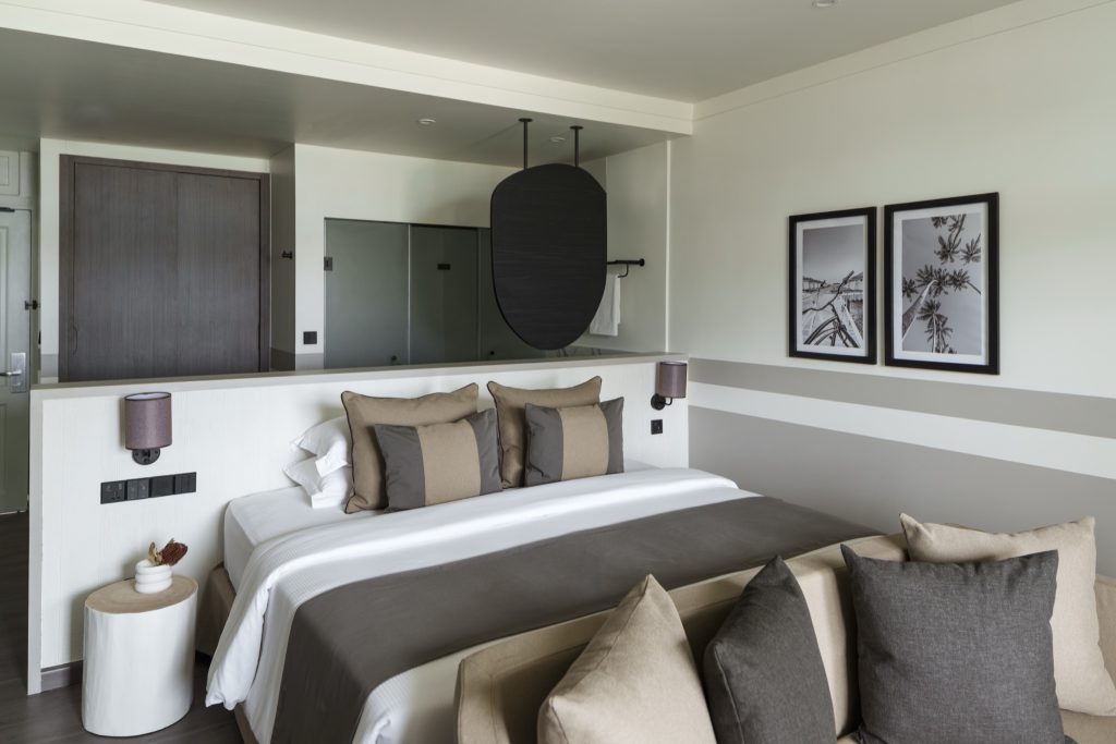 Modernes Hotelzimmer Beach Pavilion Sunset mit großem Doppelbett, neutralen Farben und schwarz-weißen Fotografien an der Wand