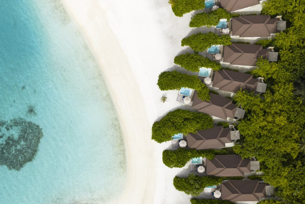 Luftaufnahme der Grand Beach Villa mit dunklem Ziegeldach und privatem Pool am Strand auf den