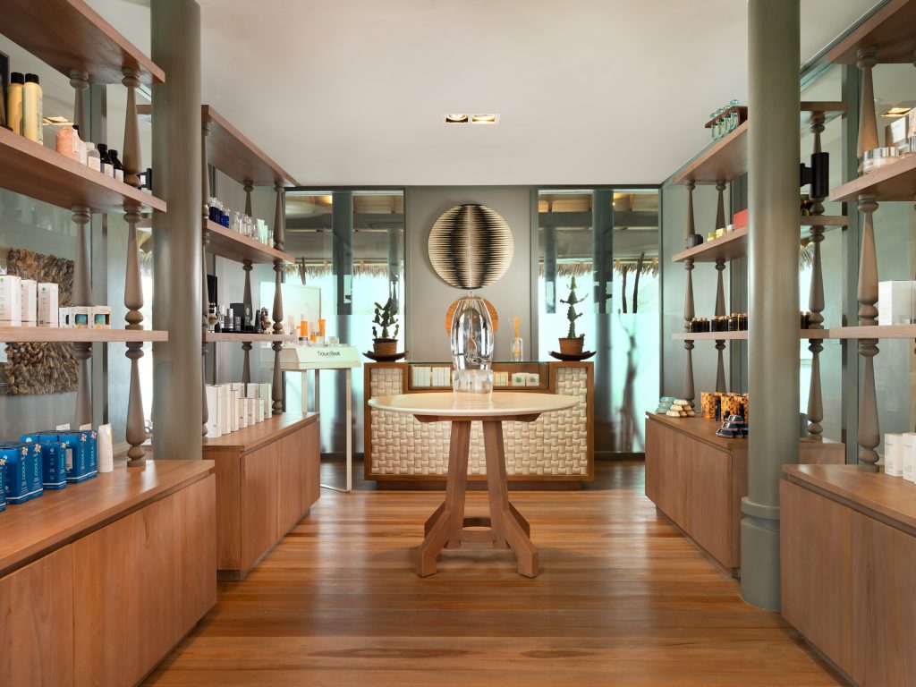 Verkaufsraum im Vakkaru Maldives Wellness Spa mit Holzmöbeln, Regalen, runden Tisch und Tageslicht
