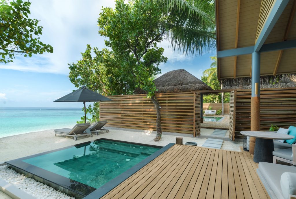 Terrasse der Four Bedroom Beach Pool Residence im Vakkaru Maldives mit Pool, Liegestühlen, Sonnenschirm und Meerblick