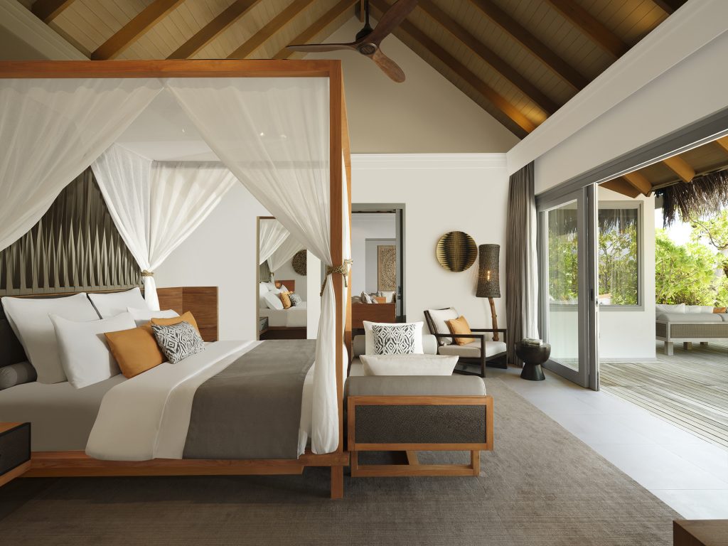 Geräumiges One Bedroom Beach Pool Residence Zimmer mit Himmelbett, Holzdecke und großer Glasschiebetür zur Terrasse