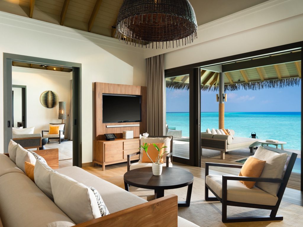 Zimmer der One Bedroom Over Water Pool Residence mit Sofa, Sessel, Couchtisch und Meerblick auf den