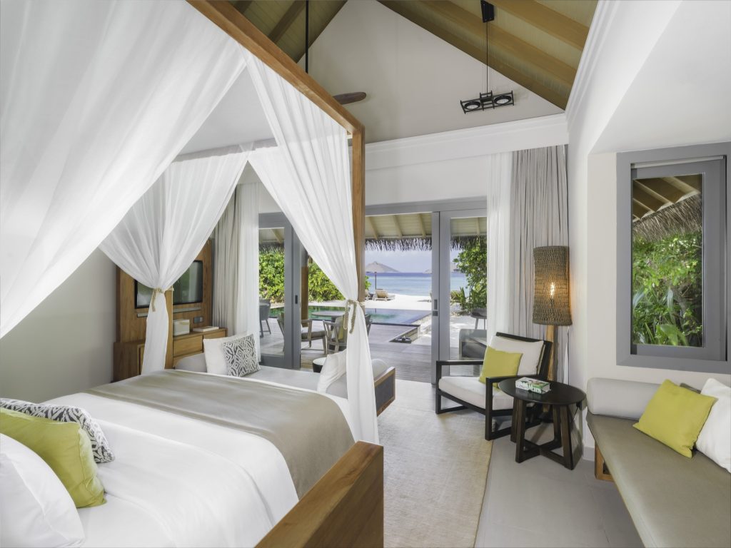 Zimmer der Two Bedroom Beach Pool Residence im Vakkaru Maldives mit Himmelbett, Sofa, Terrasse und Meerblick