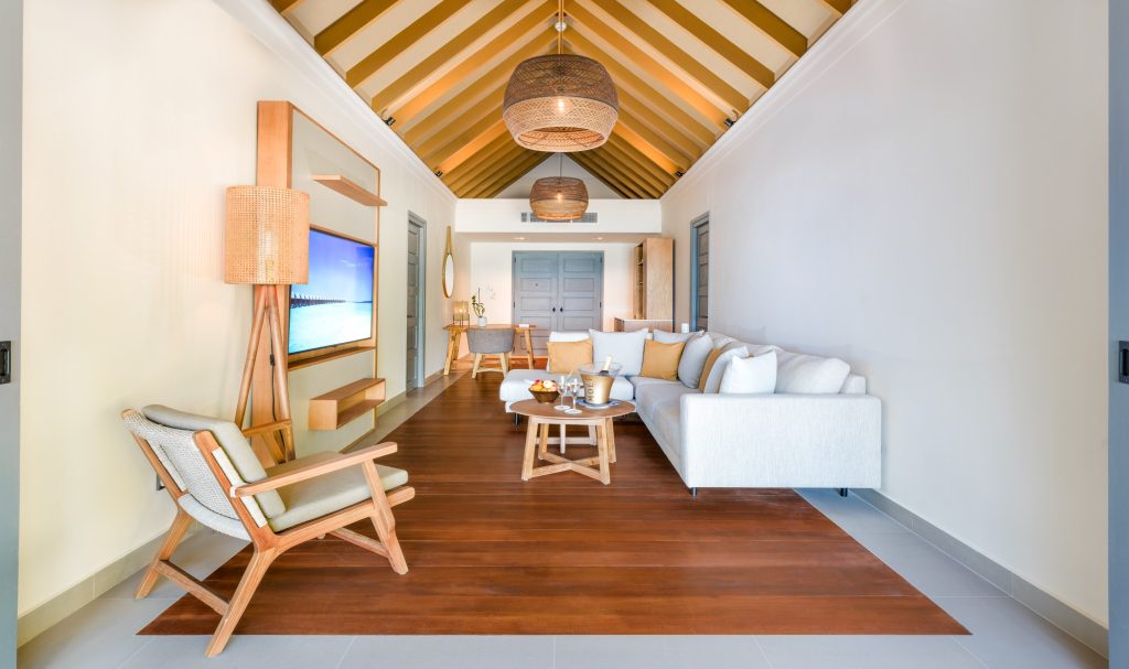 Zimmer der Two Bedroom Beach Pool Residence mit Sofa, Couchtisch, Sessel, Schreibtisch und geflochtenen Lampen