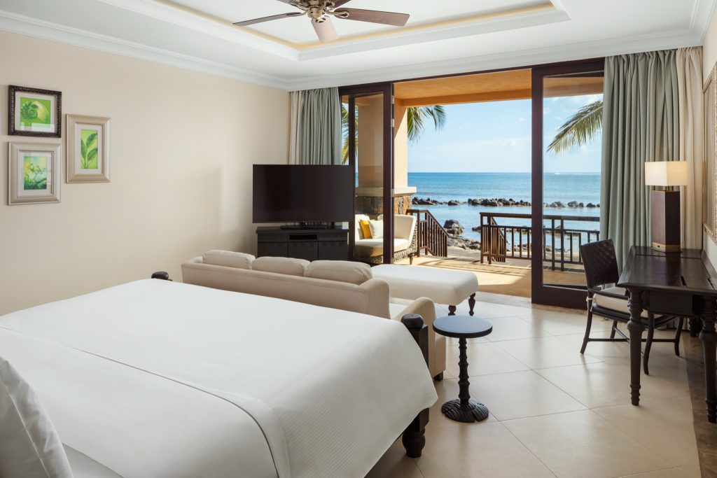 Banyan Suite Zimmer mit großem Bett, Wohnbereich, Schreibtisch und Terrasse mit Meerblick
