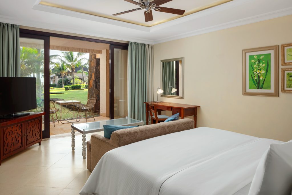 Hotelzimmer der Junior Suite mit großem Bett, Sofa, Glastisch, Schreibtisch und Terrasse