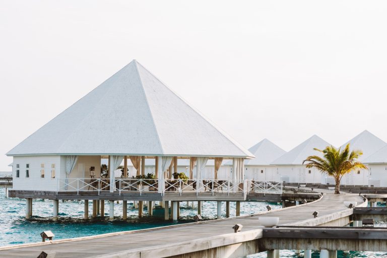 Weißer Pavillon restaurant-horizon auf Pfählen über Wasser mit Holzelementen und Holzbrücke im Diamonds Thudufushi Maldives.