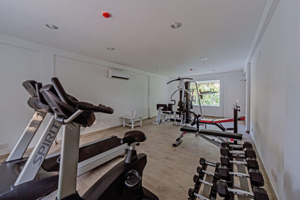 Fitnessraum im Sandies Bathala Maldives mit Laufband, stationärem Fahrrad, Kraftgeräten und Hanteln