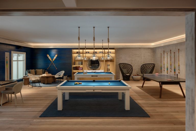 Freizeitraum mit Billardtischen, Tischtennistisch, blauen Wänden und Holzboden im Six Senses Kanuhura
