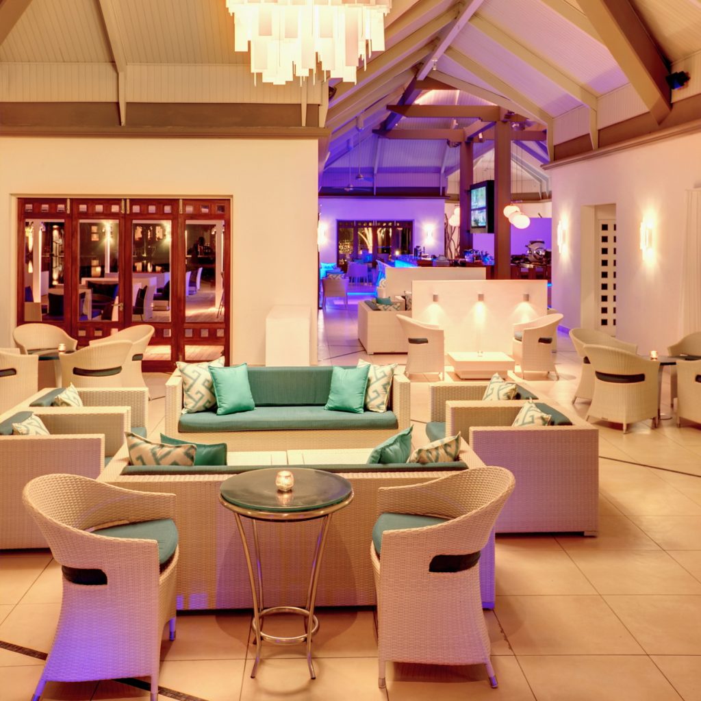 Bar B Bar im Tamassa Bel Ombre mit cremefarbenen Rattanmöbeln, türkisfarbenen Kissen und Holz-Metall-Tischen