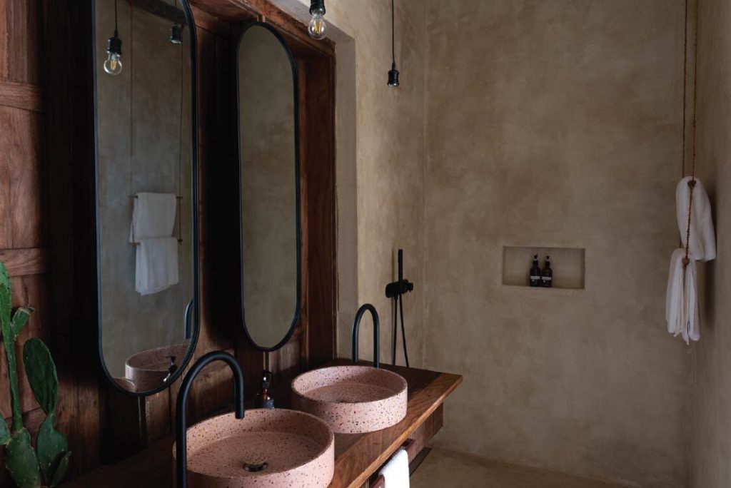 Badezimmer im Be Zanzibar Stone Town Double mit rosa Terrazzo-Waschbecken, ovalen Spiegeln und Kaktus