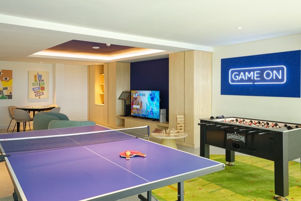 Moderner Spielraum im Eri Maldives mit blauem Tischtennistisch, rotem Schläger, Tischfußballtisch und Flachbildfernseher