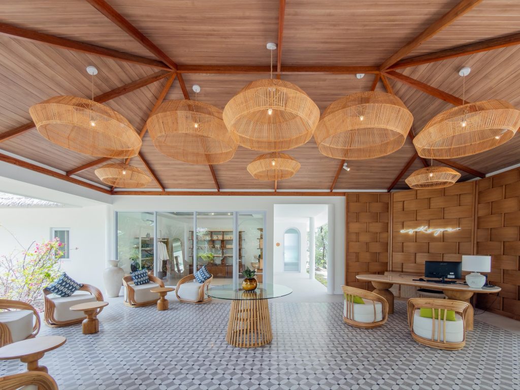 Helle Hotel-Lobby im Wellness Eskape Spa Eri Maldives mit Holzdecke, Sesseln und großen Glastüren