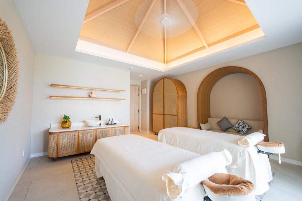 Spa-Raum im Eri Maldives mit zwei Massagebänken, hellem Holz, geometrischem Teppich und weichem Licht
