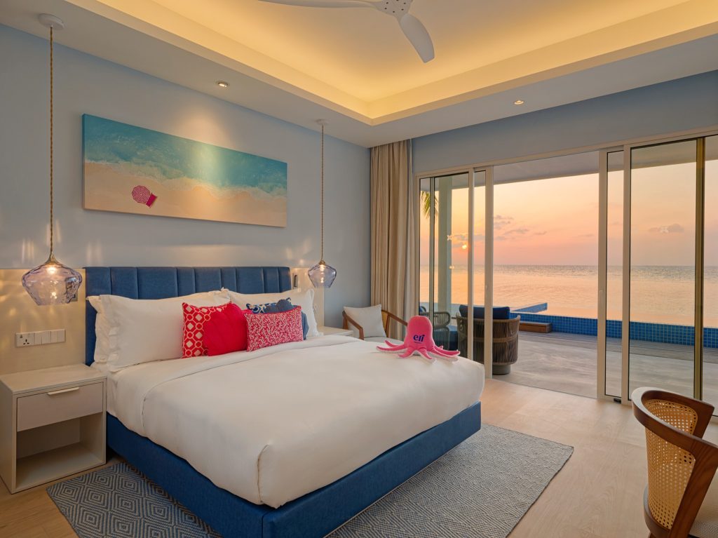 Modernes Hotelzimmer Beach Pool Villa mit großem Bett, blauen und weißen Bezügen, Meerblick und Holzmöbeln