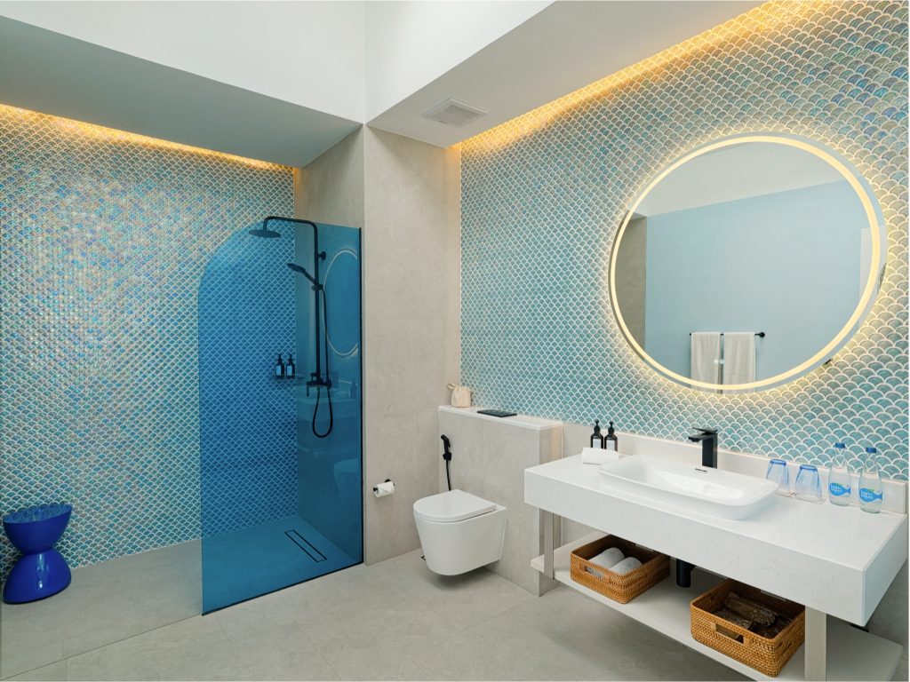 Modernes Badezimmer im Eri Maldives mit fischschuppenartigen blauen Mosaikfliesen und runder Spiegelbeleuchtung