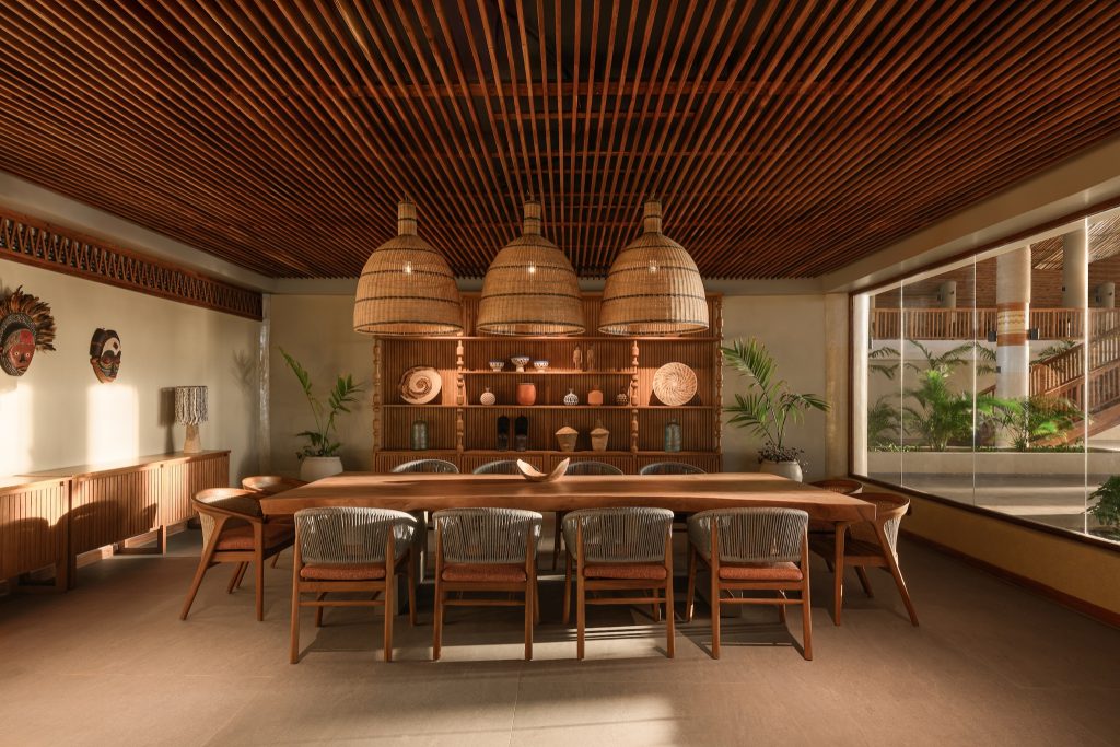 Barbereich Palm Court im JAZ Elite Aurora mit Holztisch, geflochtenen Lampenschirmen und afrikanischen Masken
