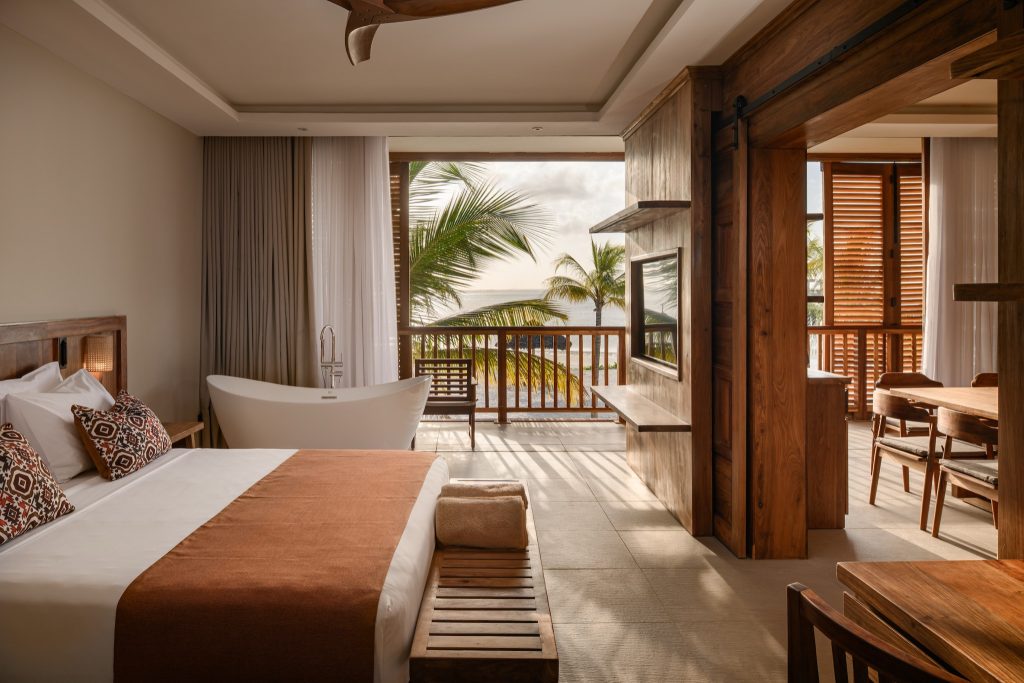 Royal Suite Zimmer mit großem Bett, freistehender Badewanne und Balkon mit Blick auf Küste und Palmen in Sansibar