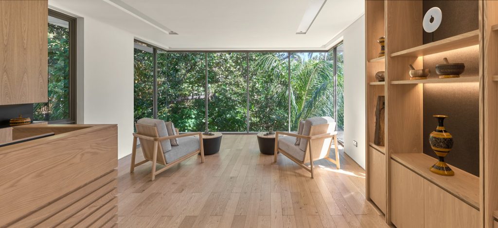 Heller Wellness Spa Raum mit großen Fenstern, Holzfußboden, zwei Sesseln und offenen Regalen im Alila Kothaifaru Maldives