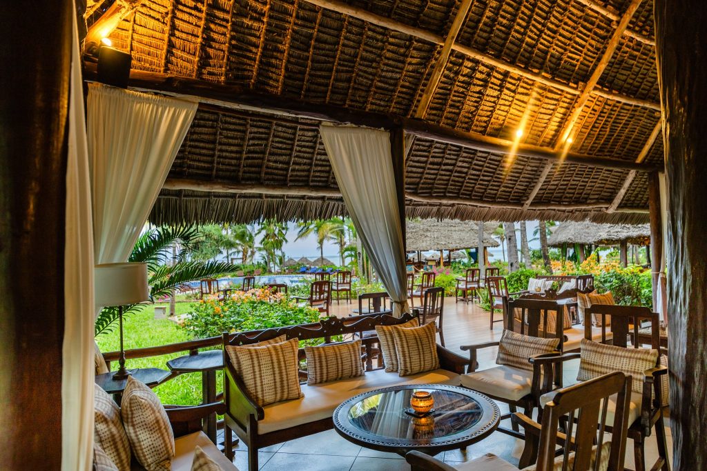 Offene Bar Safari Bar im Breezes Beach Club And Spa mit dunklen Holzmöbeln und gemusterten Kissen