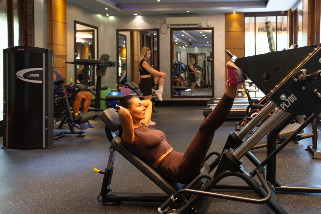 Fitnessraum im Furaveri Maldives mit Leg-Press, Cardiogeräten, Hantelbänken und mehreren Trainierenden