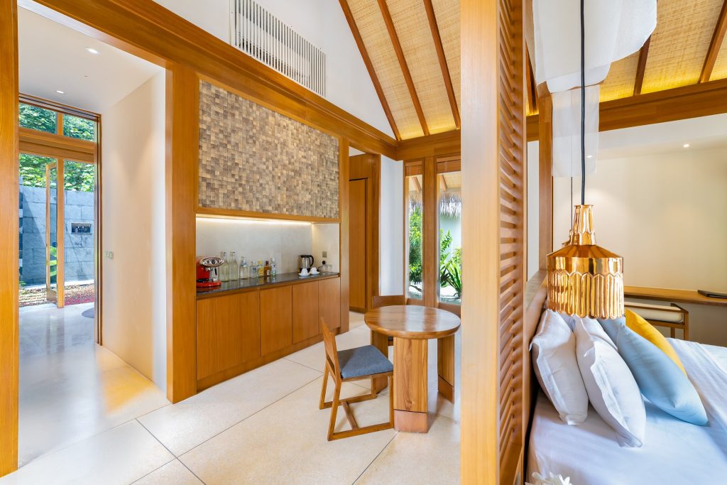Hotelzimmer der Beach Pool Villa im Furaveri Maldives mit Holztisch, grauem Stuhl, hellem Holz