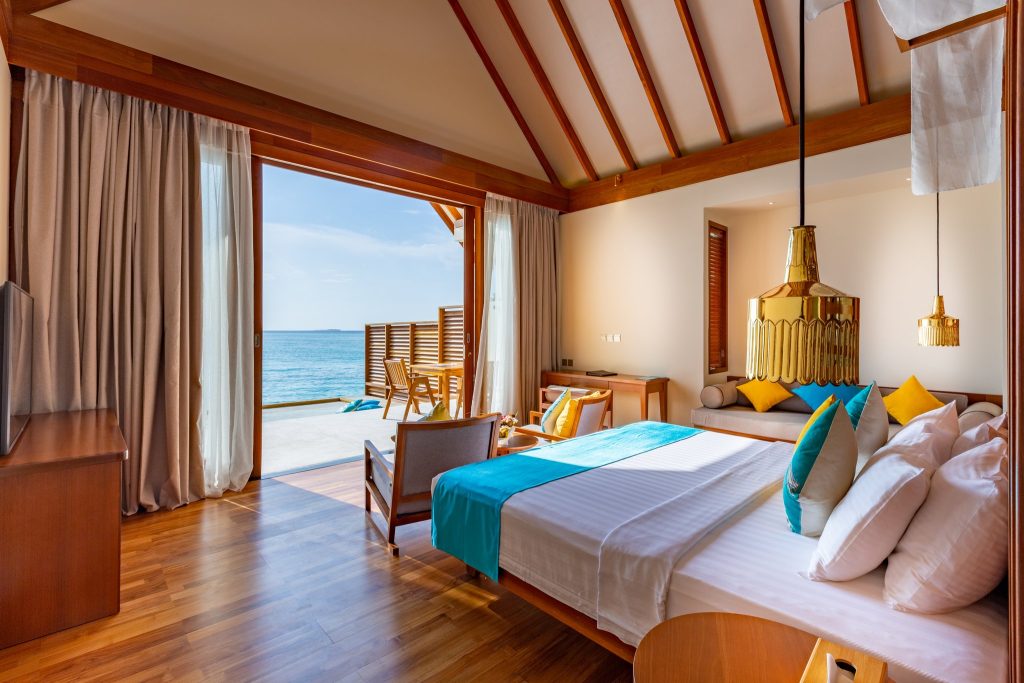 Zimmer der Furaveri Maldives Ocean Villa Infinity mit Holzdecke, großen Schiebetüren und Meerblick
