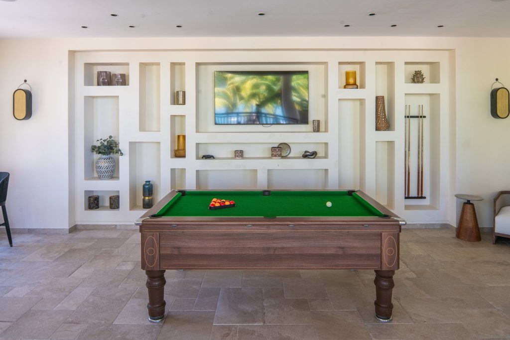 Moderner Barraum im Hilton Mauritius Resort & Spa mit Billardtisch, Regal und Flachbildfernseher
