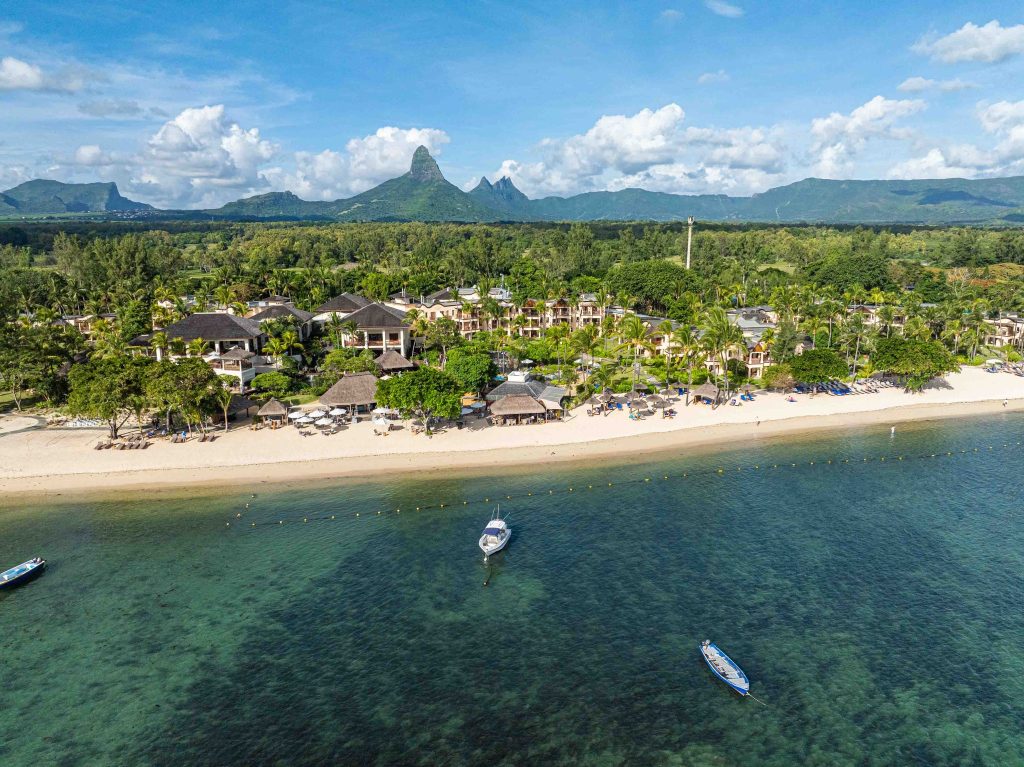 Luftaufnahme des Hilton Mauritius Resort & Spa mit Strohdachgebäuden, Palmen, weißem Sandstrand und türkisfarbenem Meer